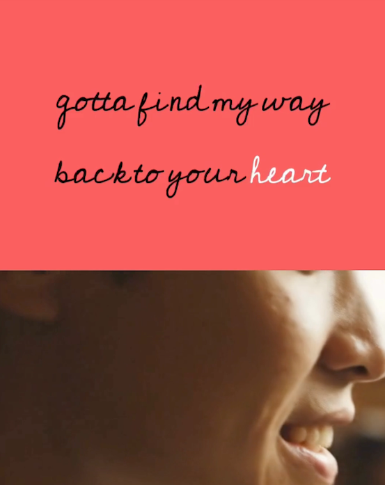 An image of a lyric video above a person singing.