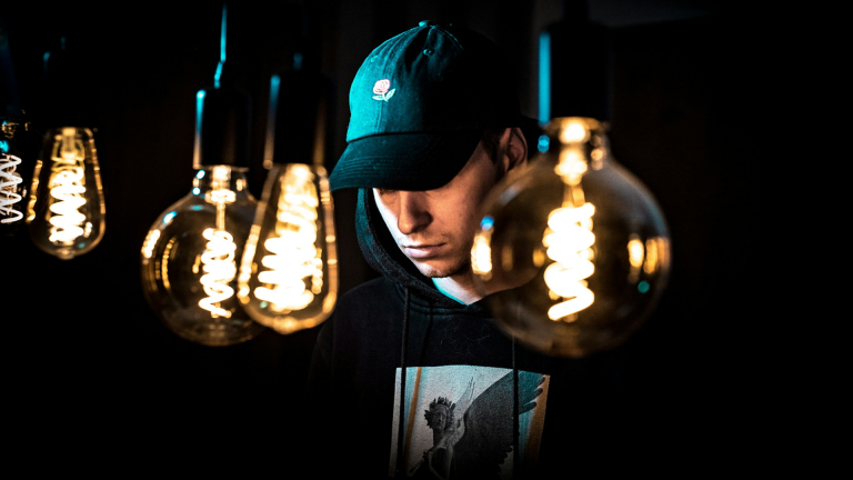 Rap artist next to lightbulbs thinking of lyric ideas.